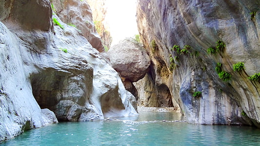 body of water near rock formations thumbnail