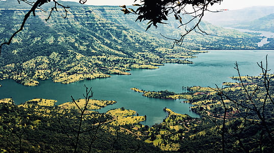 landscape photography of body of water surrounded by green mountains thumbnail