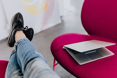 Woman using laptop computer and sitting cross legs on sofa thumbnail