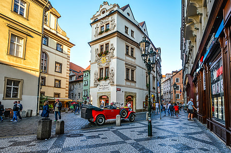 town with lots of people and cars running in street during day thumbnail