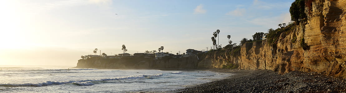 brown rock cliff surrounded by water during daytime thumbnail