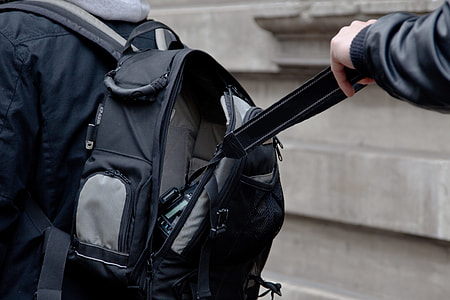 person holding black backpack strap thumbnail