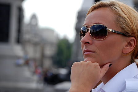 selective focus photo of woman wearing gold-colored framed aviator-style sunglasses thumbnail
