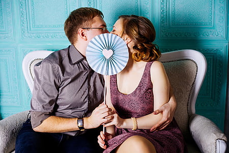 woman and man sitting on couch kissing thumbnail