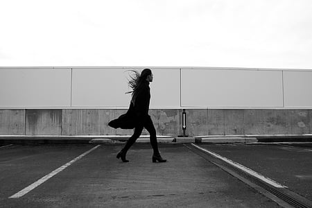 grayscale photography of woman walking on road thumbnail