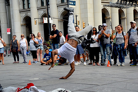 photography of man in white t-shirt and gray pants dancing on park thumbnail