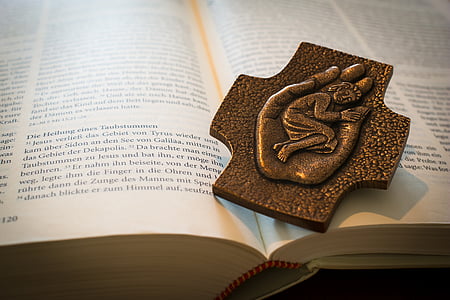 brown metal ornament on open book thumbnail