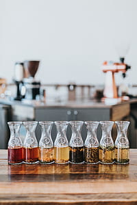 eight clear glass canisters on brown wooden surface thumbnail