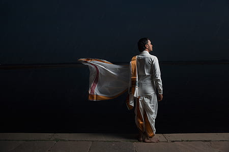 man standing in front of body of water facing sideways thumbnail