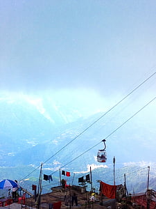 people riding cable car overlooking mountains at daytime thumbnail
