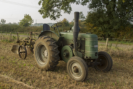 green tractor near trees thumbnail