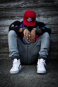 man in gray pants sitting on ground thumbnail
