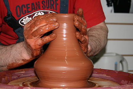 person molding clay pot thumbnail