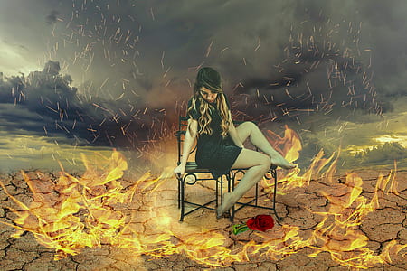 woman sitting on black steel chairs surrounded by fire thumbnail