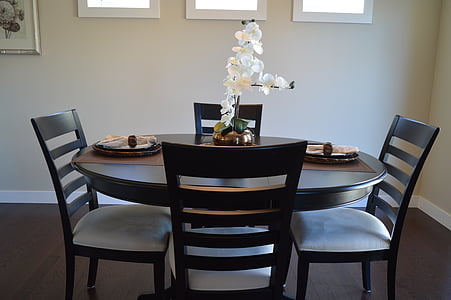 round brown wooden table with four chairs inside room thumbnail