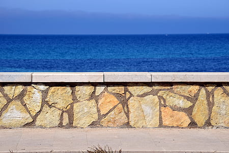 brown concrete wall near the body of water at daytime thumbnail