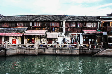 brown wooden house beside body of water thumbnail