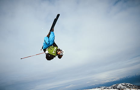 person wears snow skis jumps over the mountain thumbnail