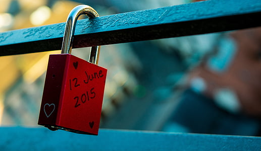 red padlock locked on black metal bar thumbnail
