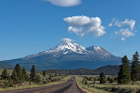 grey spalto road near white and black mountain hills under blue sky thumbnail