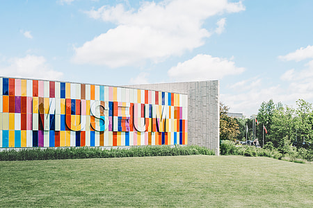 multi-colored Museum outdoor wall surrounded by green grass under blue cloudy sky thumbnail
