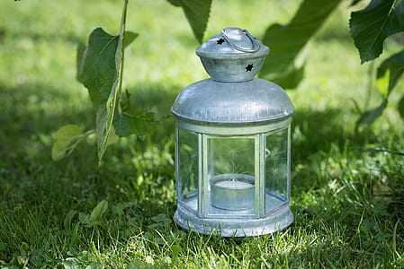 grey tealight candle lantern on green grass thumbnail