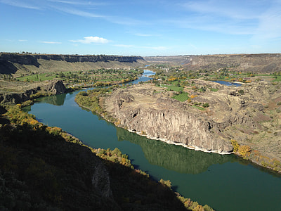 winding river between mountains under clear blue sky thumbnail