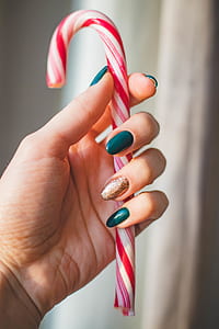 Person Showing White and Red Candy Cane thumbnail