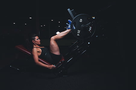 woman pushing black barbell while lying on maroon bench thumbnail