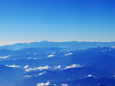 aerial photography of hills under white cloudy skies at daytime thumbnail