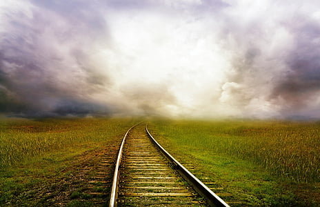 landscape photography of railway on green grass field thumbnail