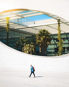 man walking beside the architectural building thumbnail