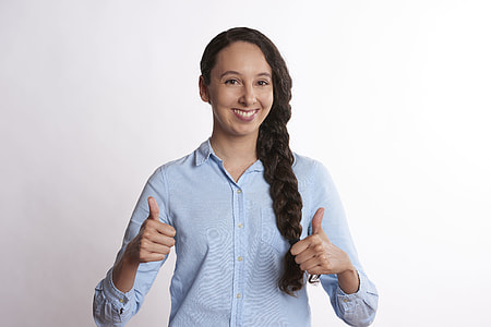 woman with braided hair wearing teal button-up dress shirt giving two thumbs up sign thumbnail