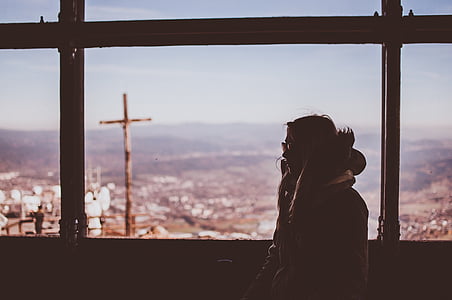 woman wearing coat near brown wooden frame of window thumbnail