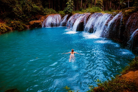 woman swimming on body of water during daytime thumbnail