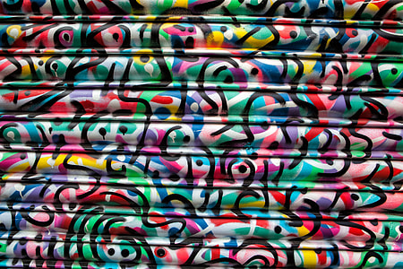 Vibrantly coloured paint swirls on a metal shop shutter thumbnail