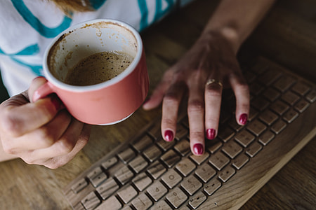 Closeup of female hands typing text on a wireless wooden keyboard thumbnail