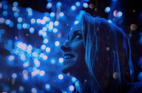 close-up photo of smiling woman while looking towards dim lights above her thumbnail