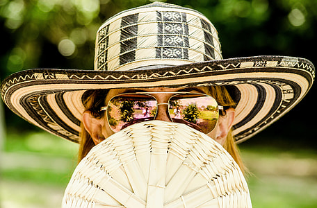 shallow focus of woman in yellow hair wearing white and black summer hat with brown frame aviator sunglasses during daytime thumbnail
