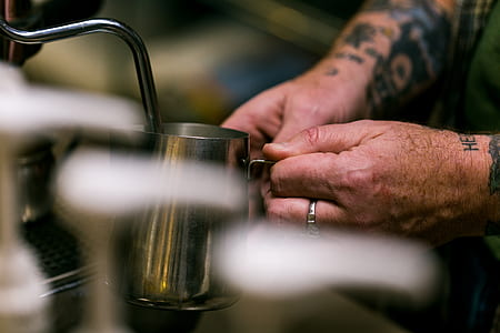 person holding gray metal cup thumbnail