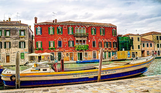 docked boat near red building under blue sky thumbnail