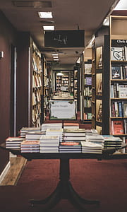 books on black pedestal table in library thumbnail