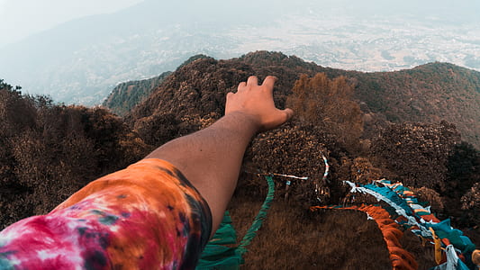person standing on mountain at daytime thumbnail