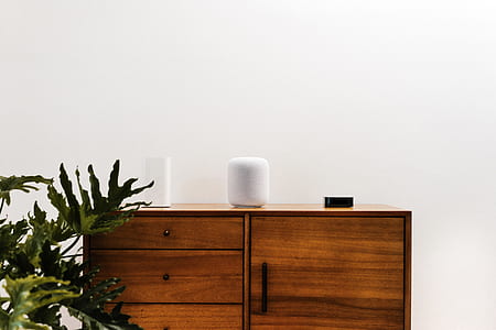 photo of white portable speaker on brown wooden drawer chest thumbnail