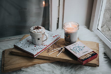 flat lane photograph of votive candle; match box; cup of beverage thumbnail