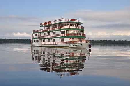 white and green boat under cloudy sky thumbnail