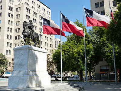 three flags near statue and buildings thumbnail