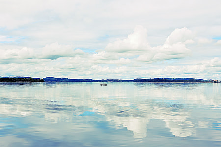 boat on calm sea near mountain under white cloudy sky at daytime thumbnail