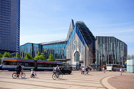people walking while others are riding bikes in the road at daytime near glass buildings thumbnail