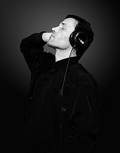 grayscale photo of man wearing dress shirt and corded headphones thumbnail